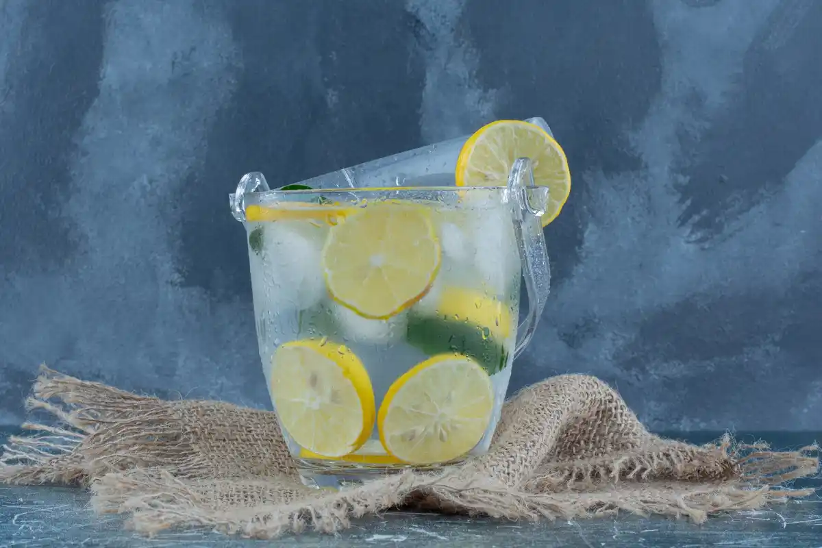 glass of fresh water with lemon slices on desk