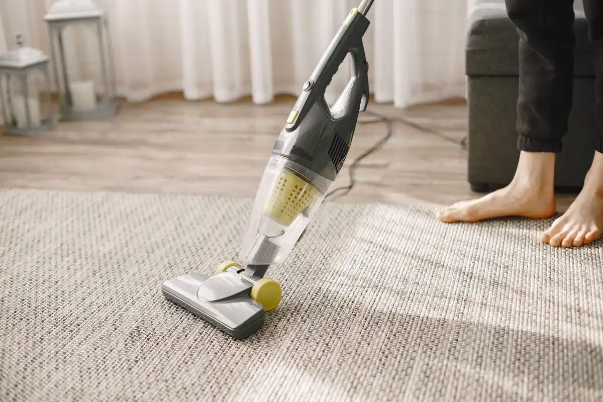 hand vacuum cleaning sofa in cozy living room
