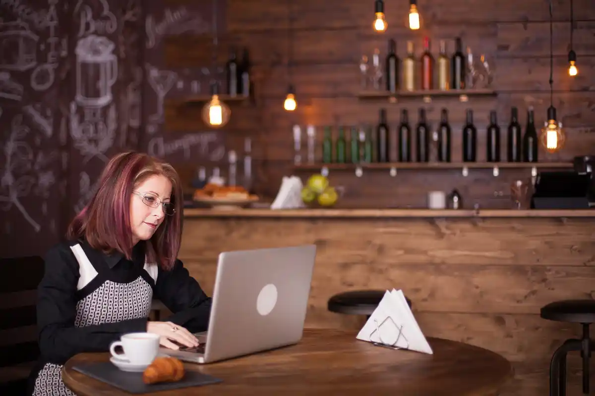 focused young professional working on laptop in cozy cafe