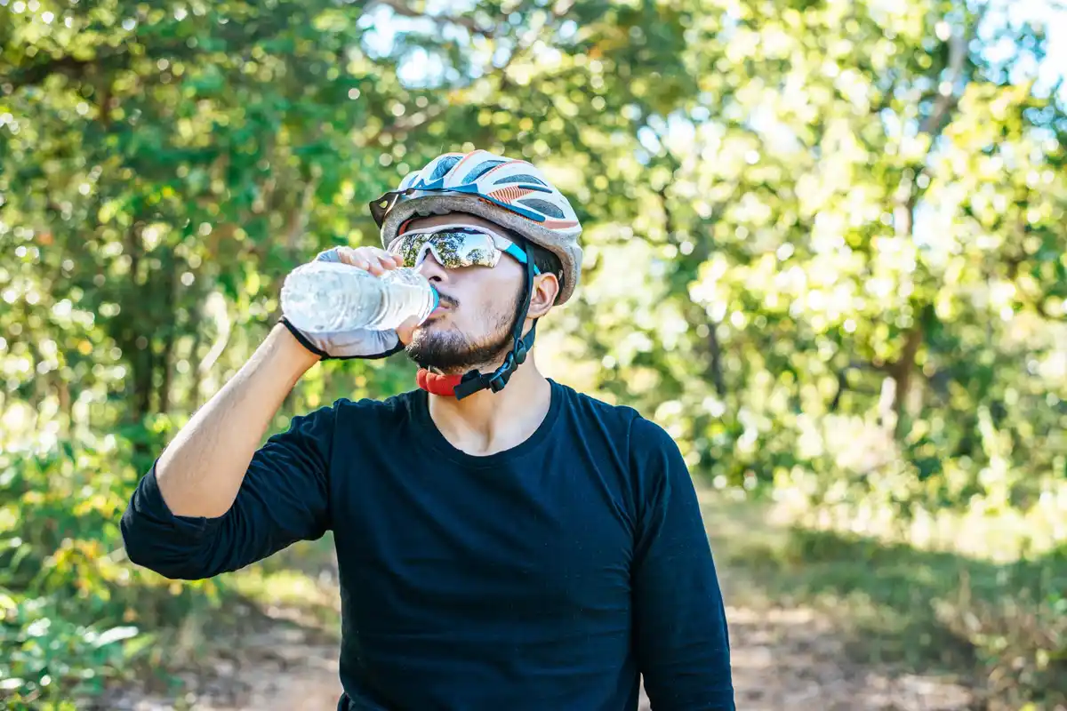 Cyclist drinking water near Dutch canal