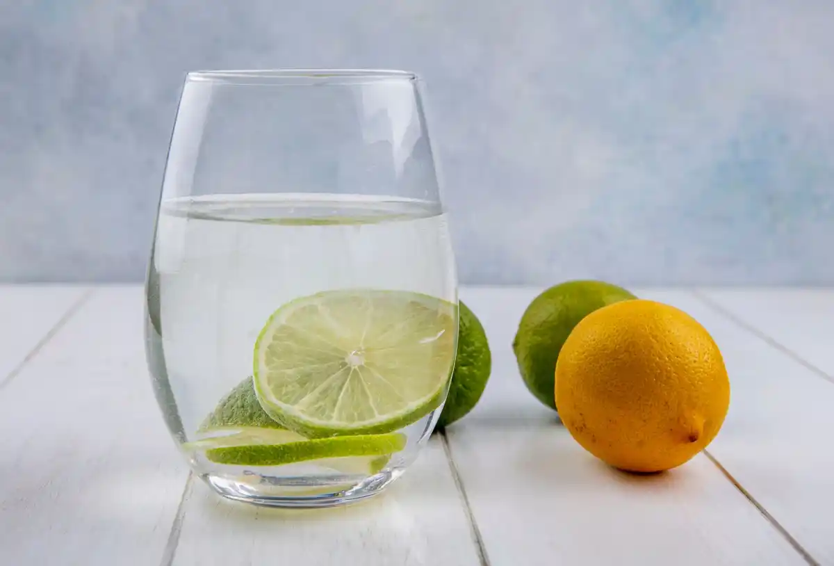 Refreshing glass of water with lemon on kitchen table