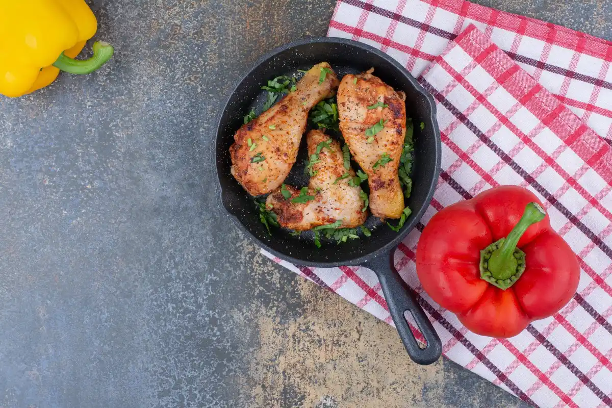 cast iron skillet with crispy chicken skin cooking