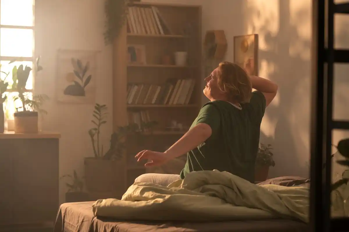 person stretching morning sunlight window