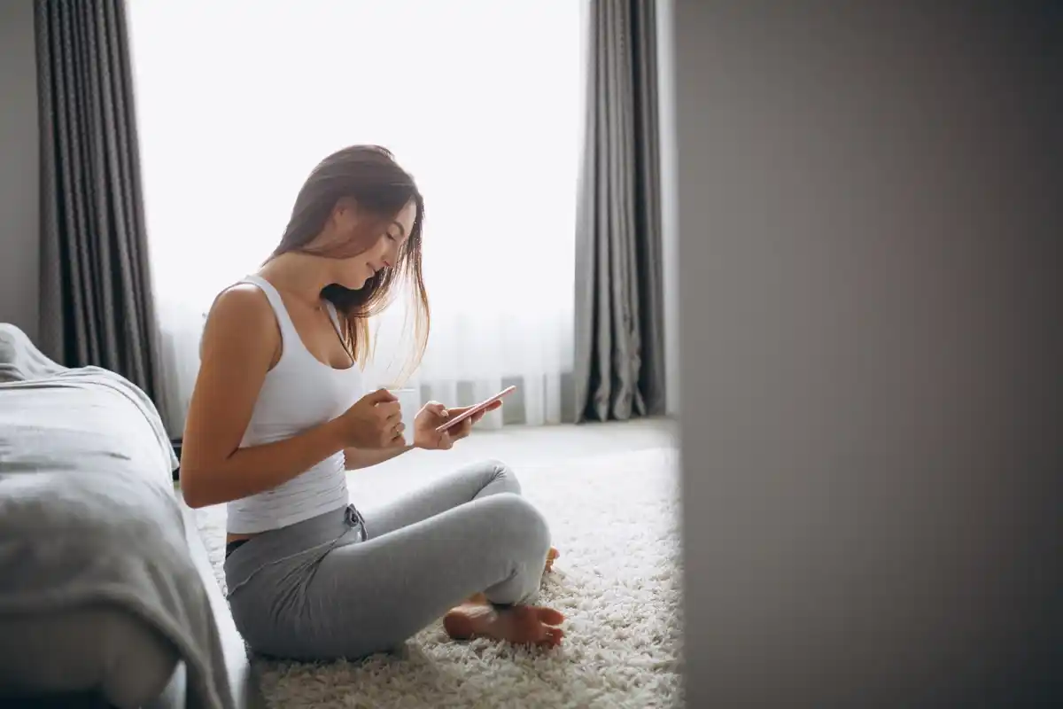 woman relaxed at home, calmly using phone, cozy atmosphere