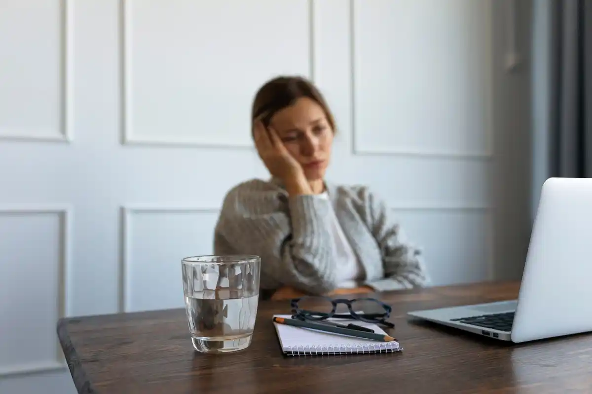 tired person at desk with coffee