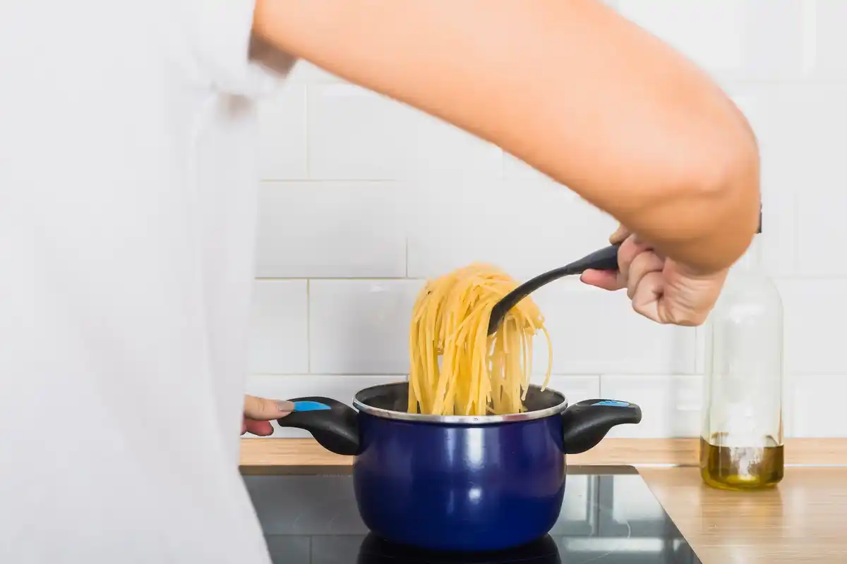 cooking pasta in broth in kitchen