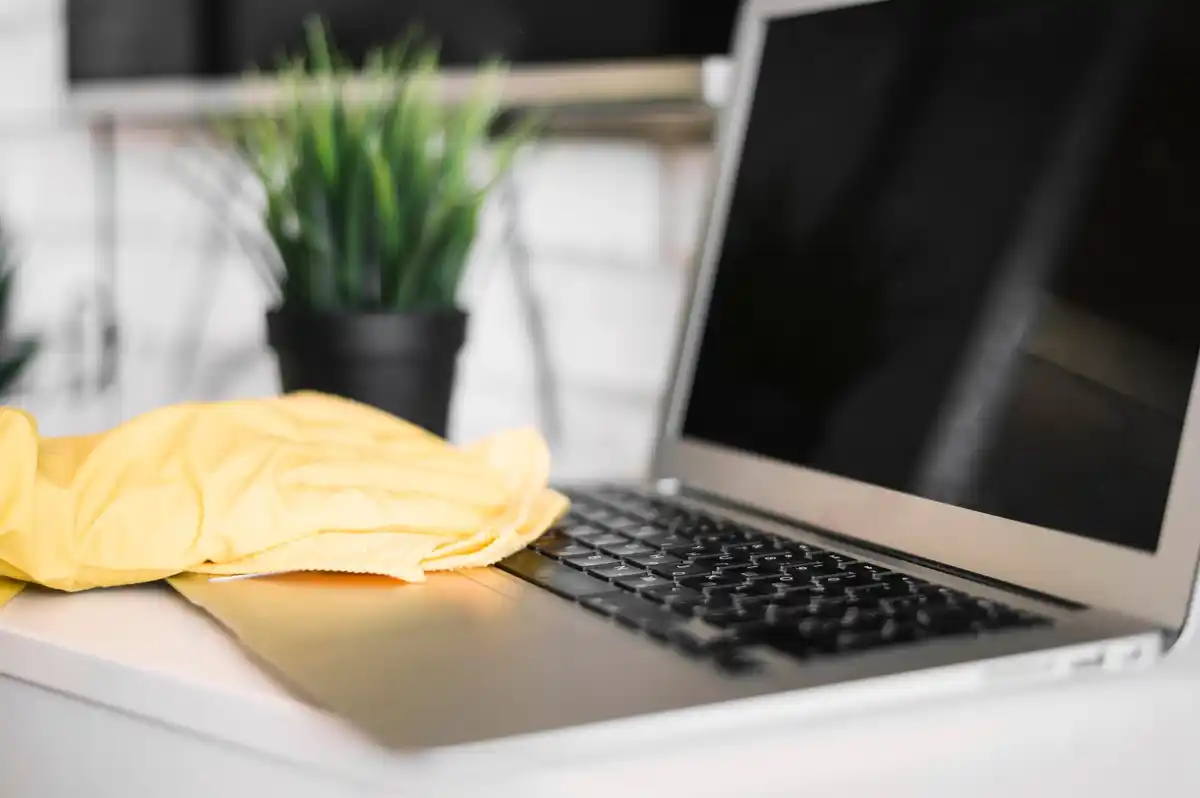 clean laptop keyboard and screen with cloth at home