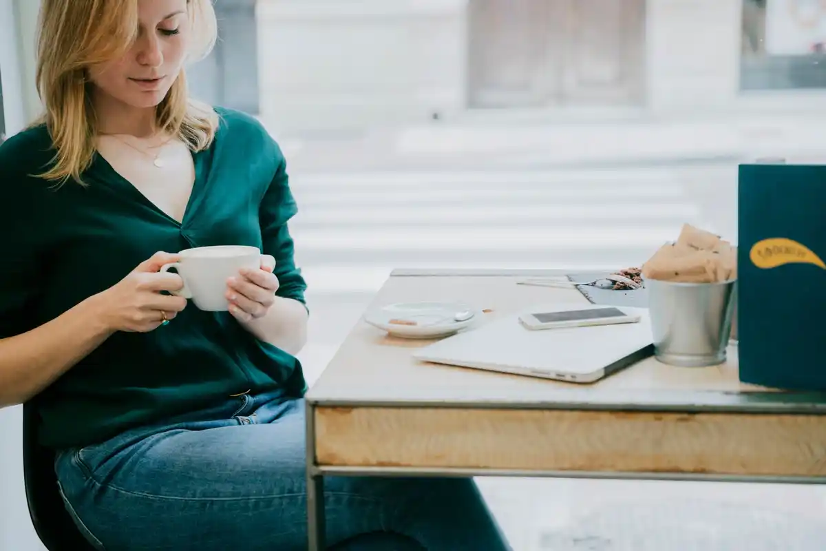 focused woman working at desk with coffee