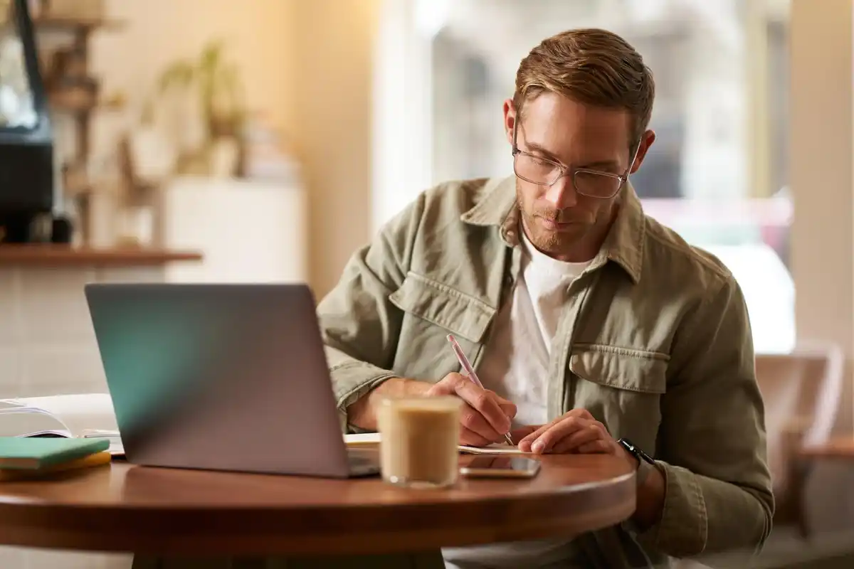 focused person working with coffee and notebook