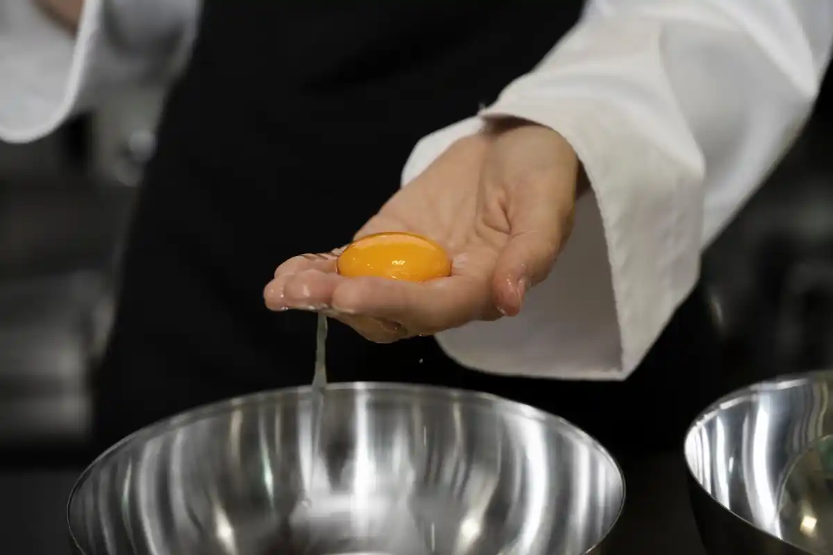 egg being poured into pan with water splash