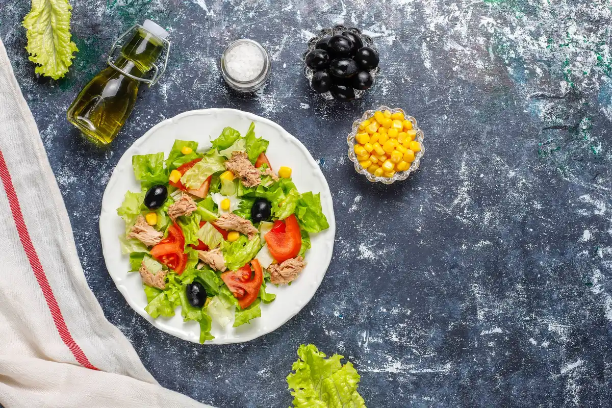 salad with olive oil drizzle and lemon wedges