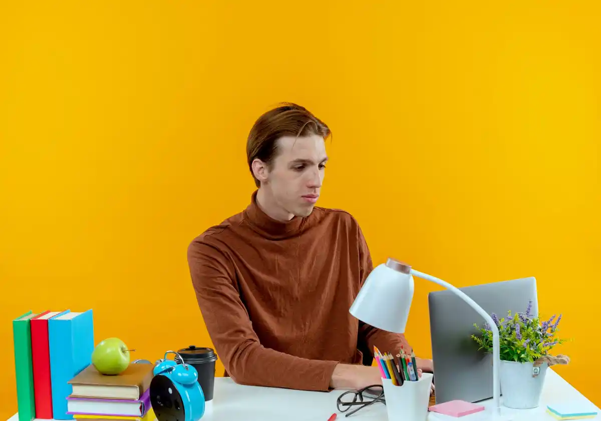 Person concentrating at desk with laptop and no distractions