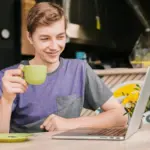 focused young professional working laptop coffee office