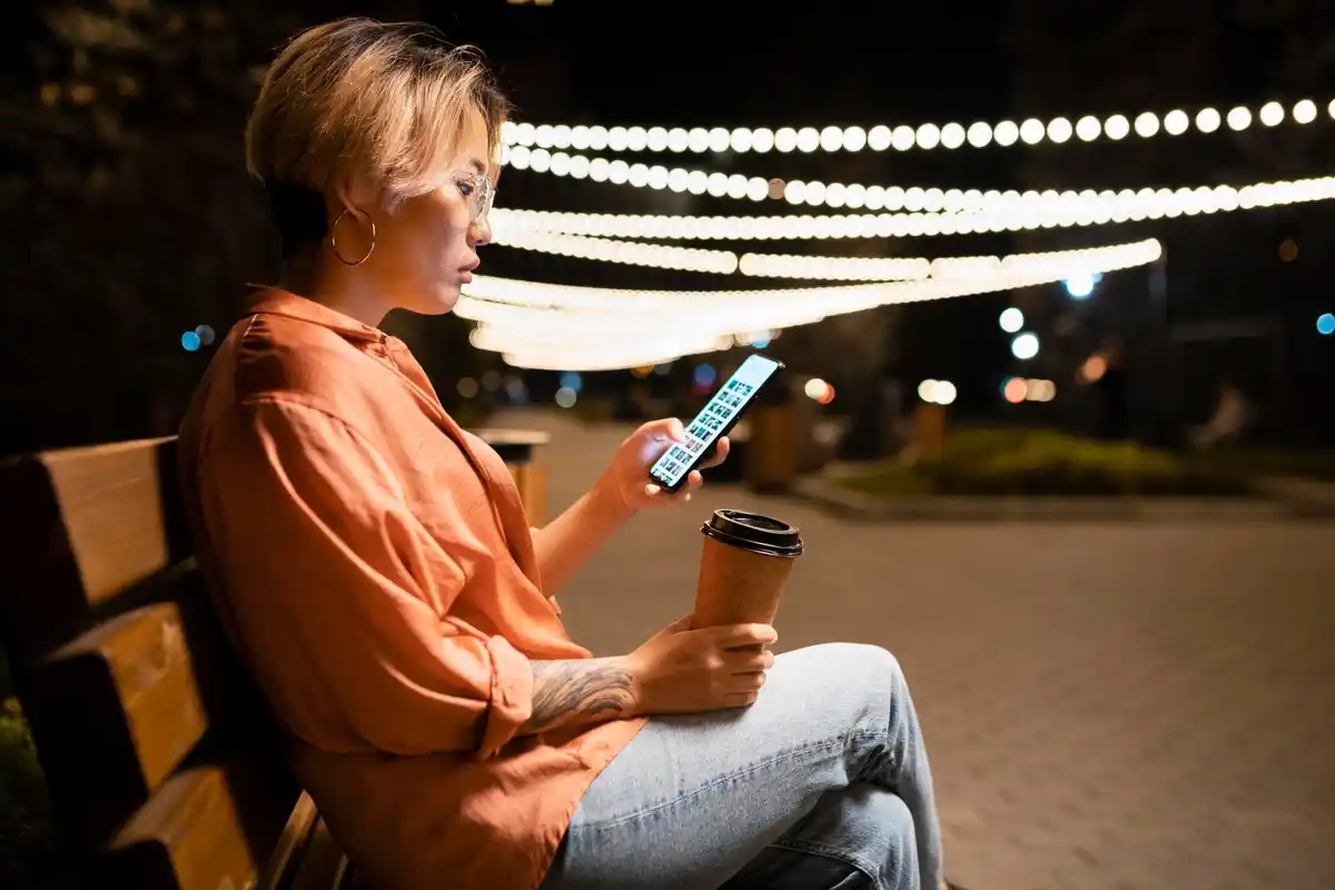 Person using TickTick app on smartphone in cozy cafe in Netherlands