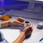 focused person working at desk with laptop and coffee