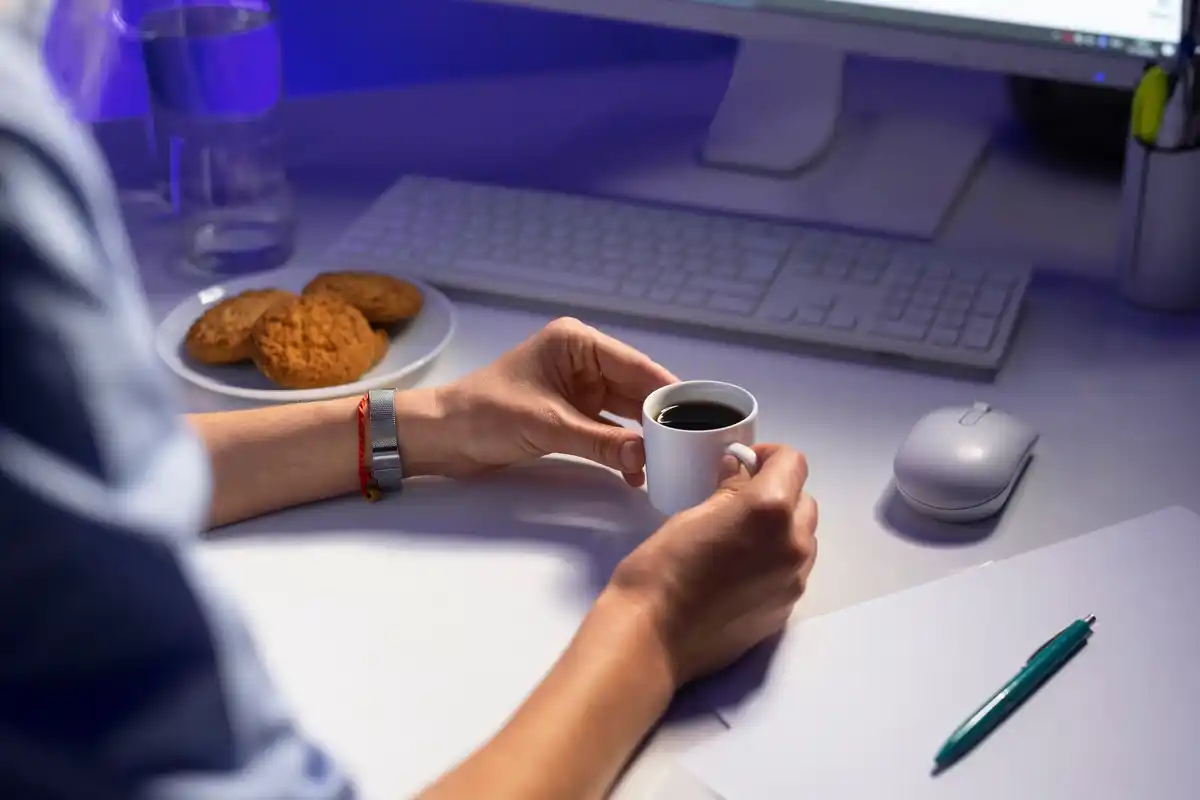 focused person working at desk with laptop and coffee
