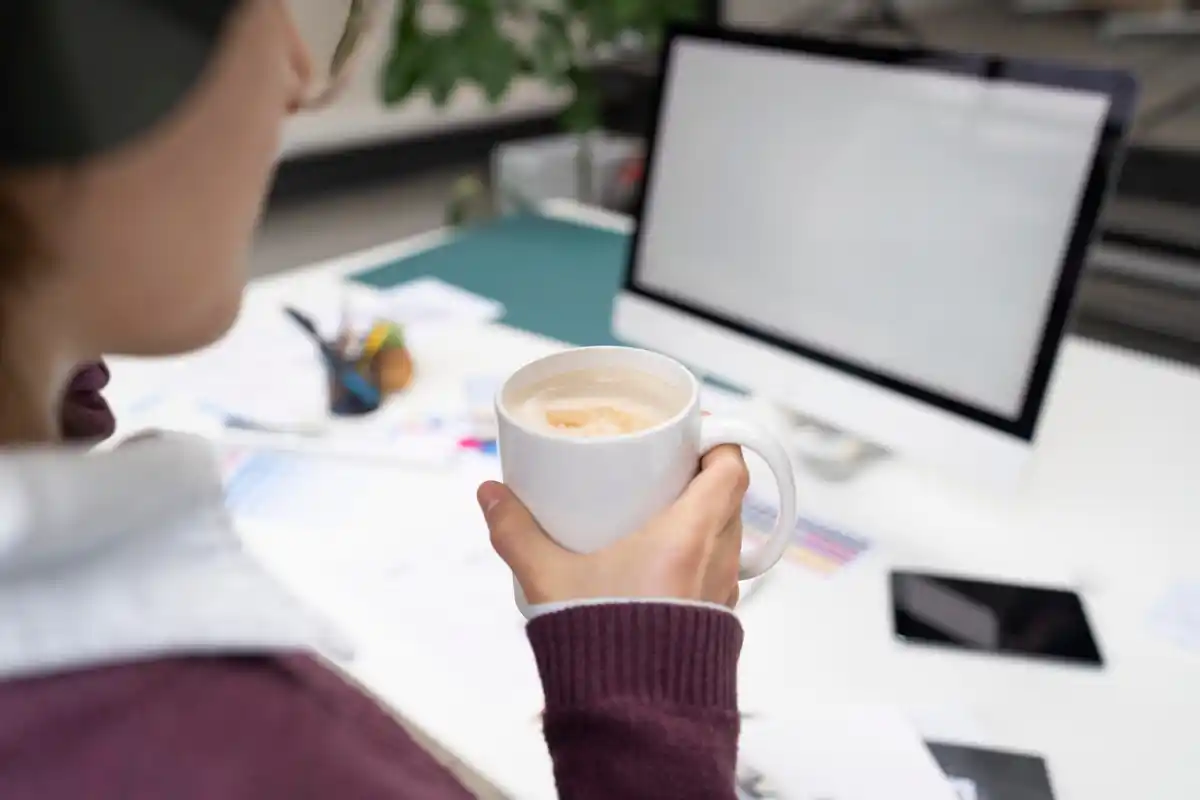 working focused at desk with laptop and coffee