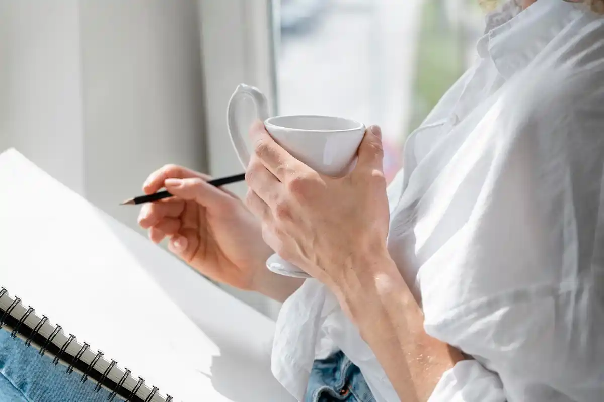focused person working with planner and coffee