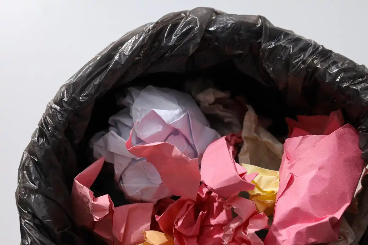 discarding old household items in a trash bag