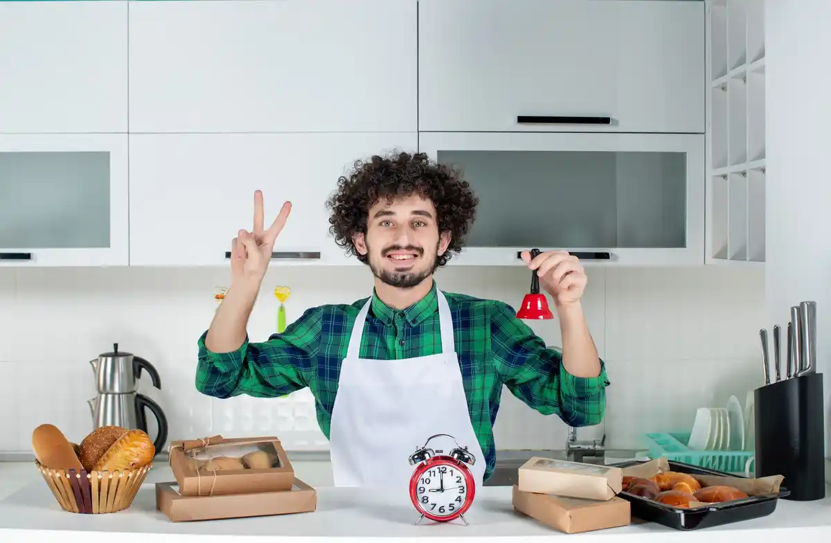 person setting a kitchen timer while tidying up a small shelf