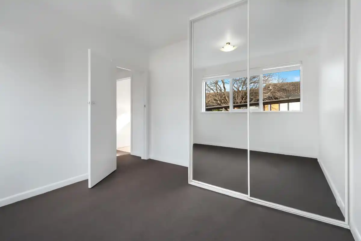 small bright living room with large wall mirror and natural light