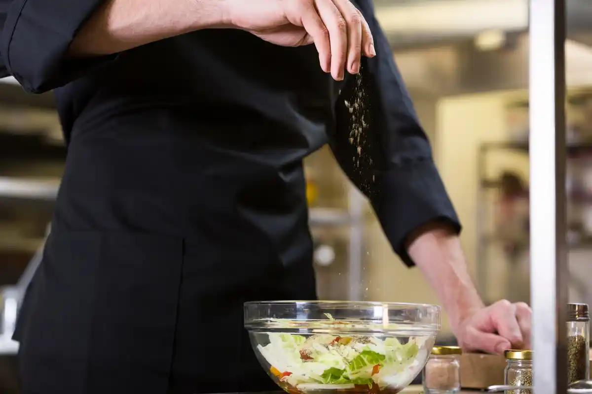 chef seasoning food at the end of cooking